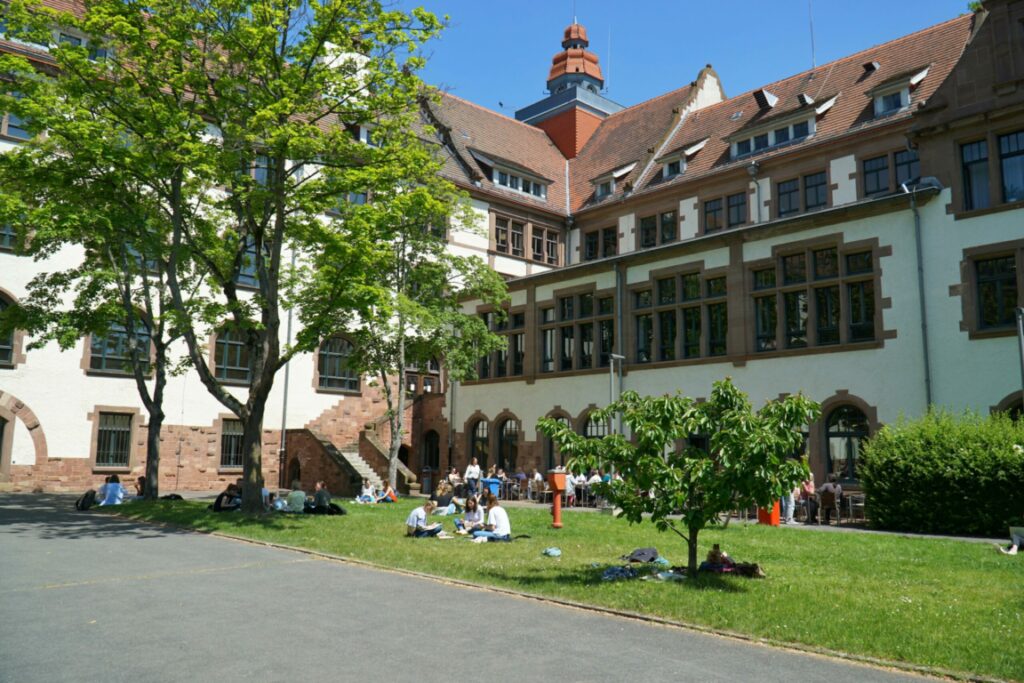 Zu sehen ist der Altbau der Pädagogischen Hochschule Heidelberg, Blick in den Innenhof im Frühling.