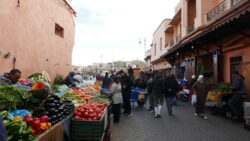 Zu sehen ist eine belebte Straße mit Marktständen in Marrakesch.