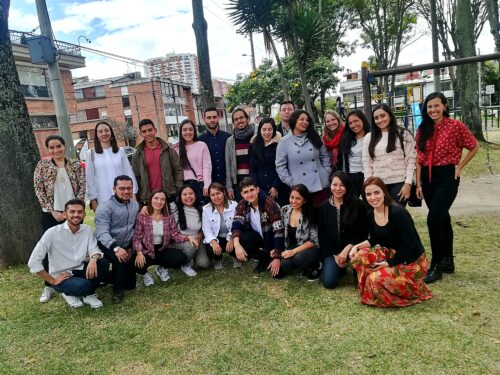 Zu sehen ist eine Alumni-Gruppe mit 22 Personen vor Hochhäusern in Bogota, Kolumbien
